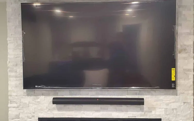Television and soundbar mounted in alignment on a finished wall