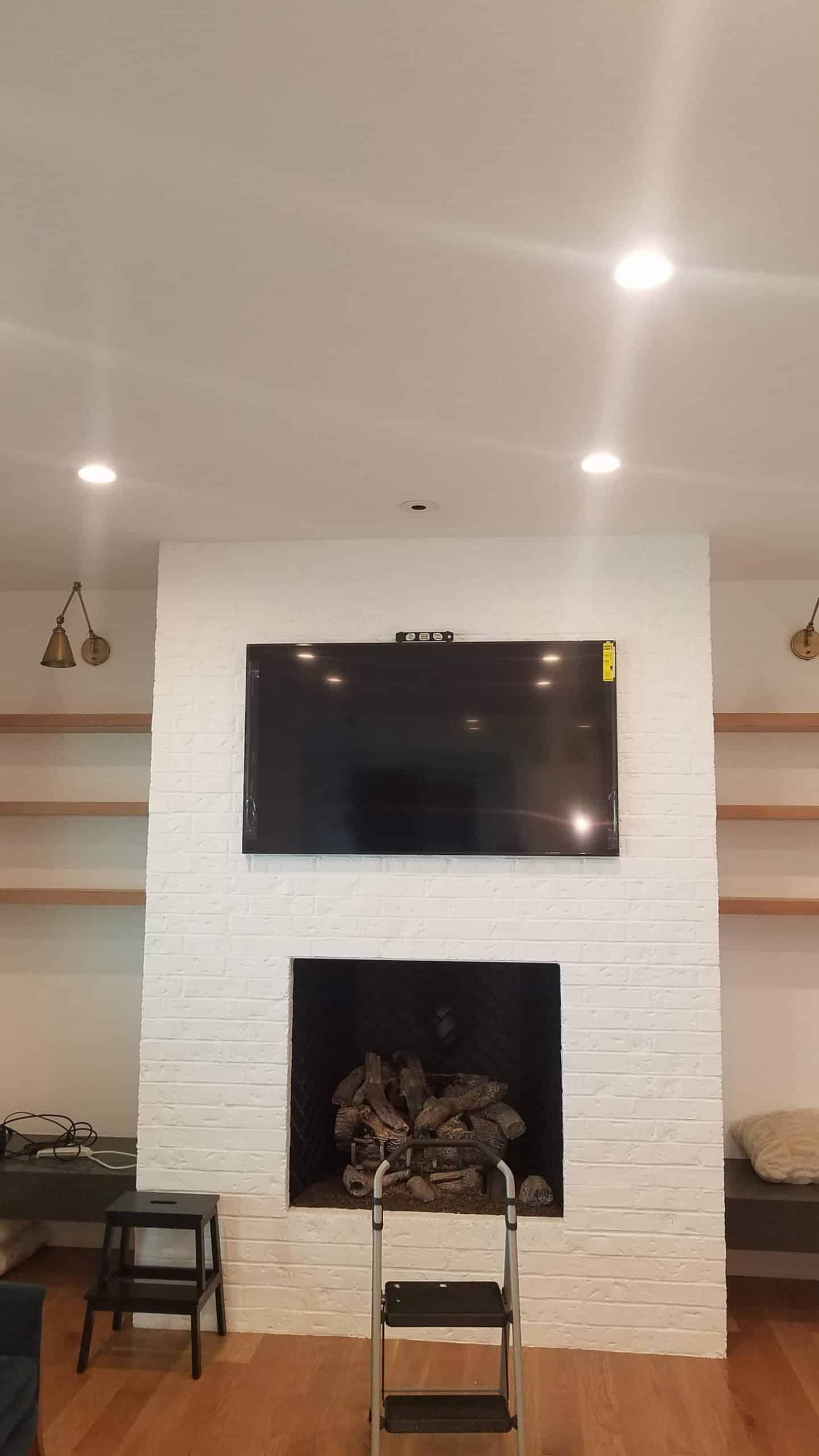 Television mounted on a white brick fireplace wall