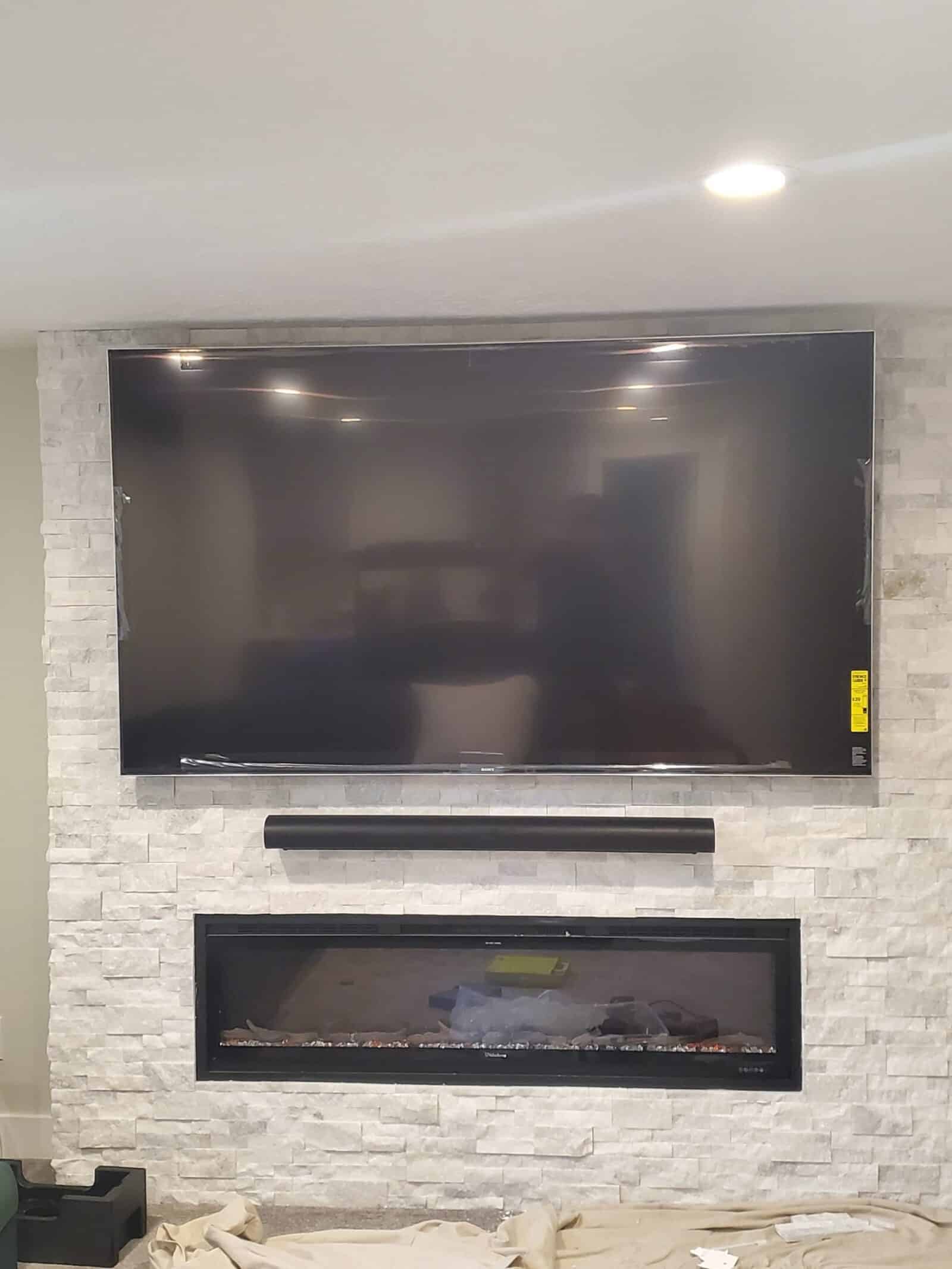 Large wall-mounted television with a soundbar installed directly below