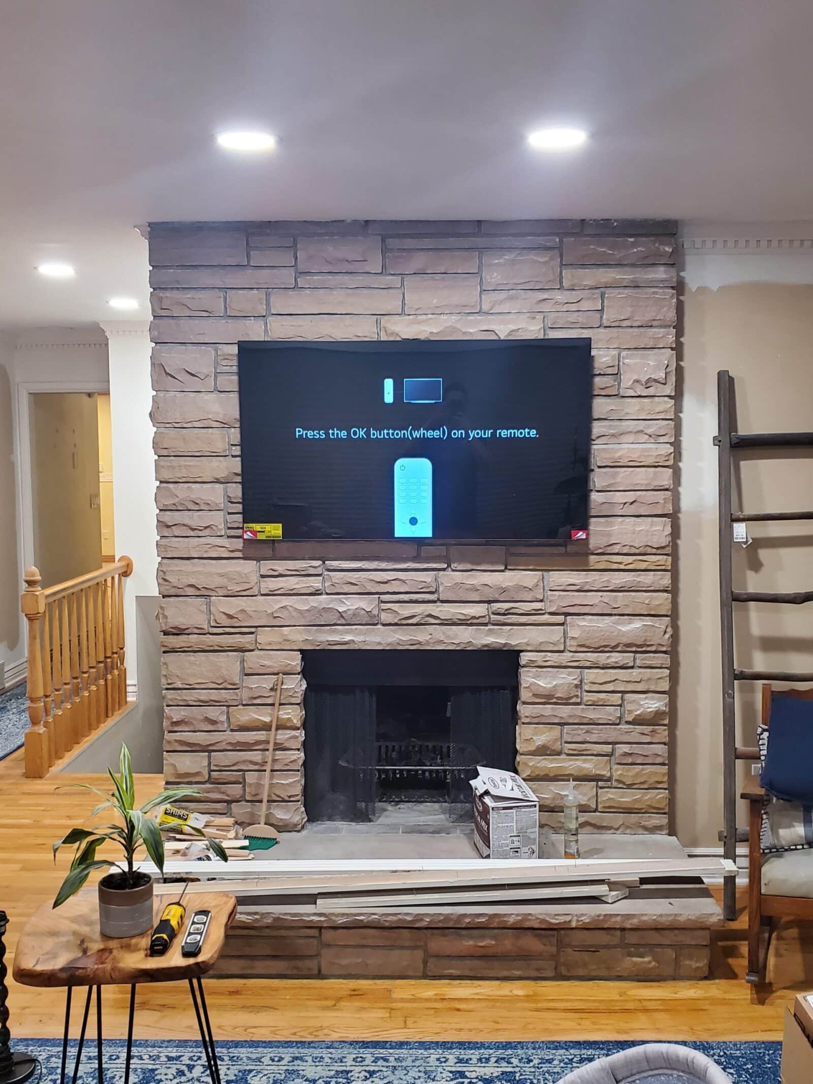 TV mounted above a stone fireplace