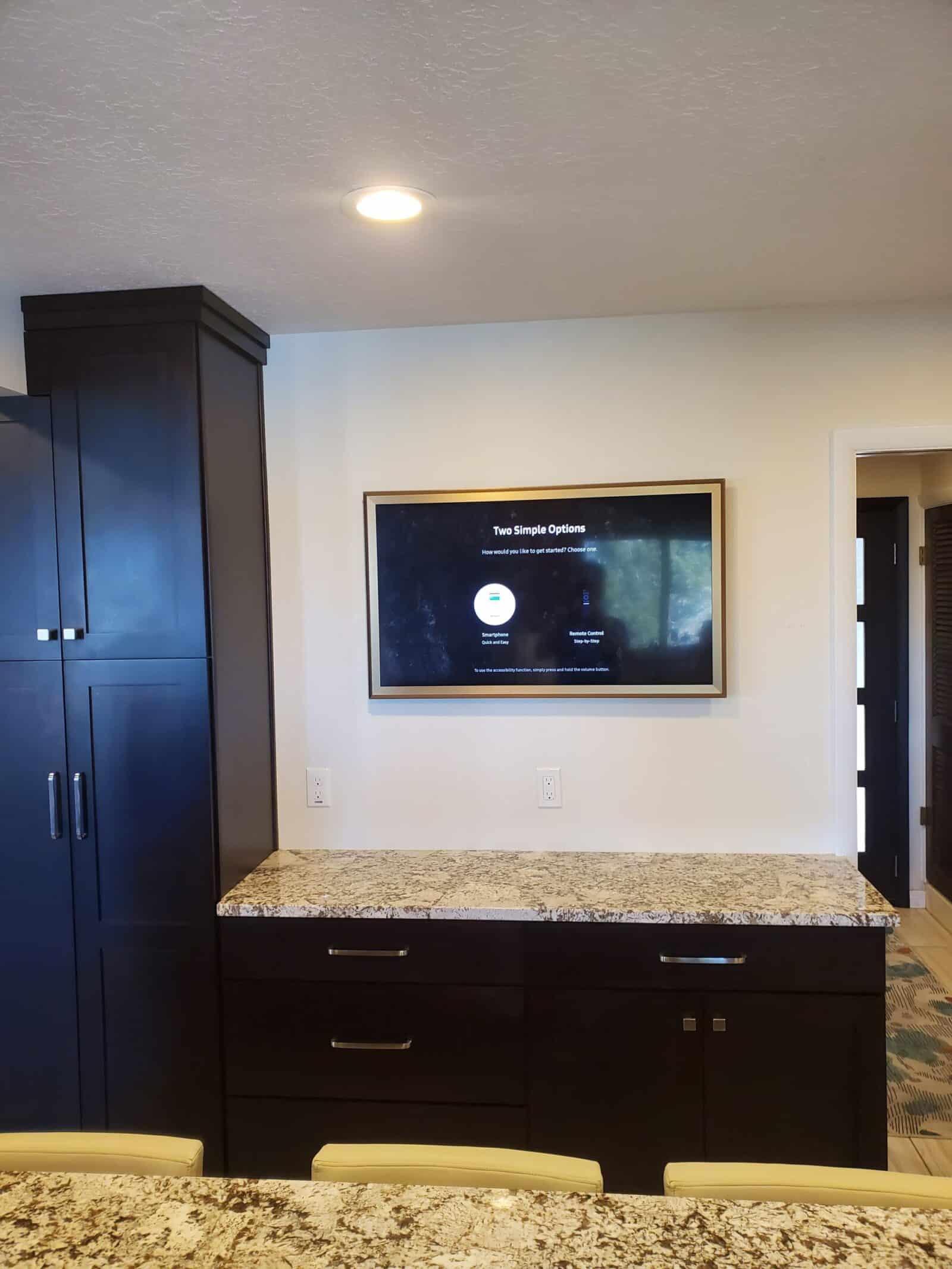 Wall-mounted TV beside built-in cabinetry