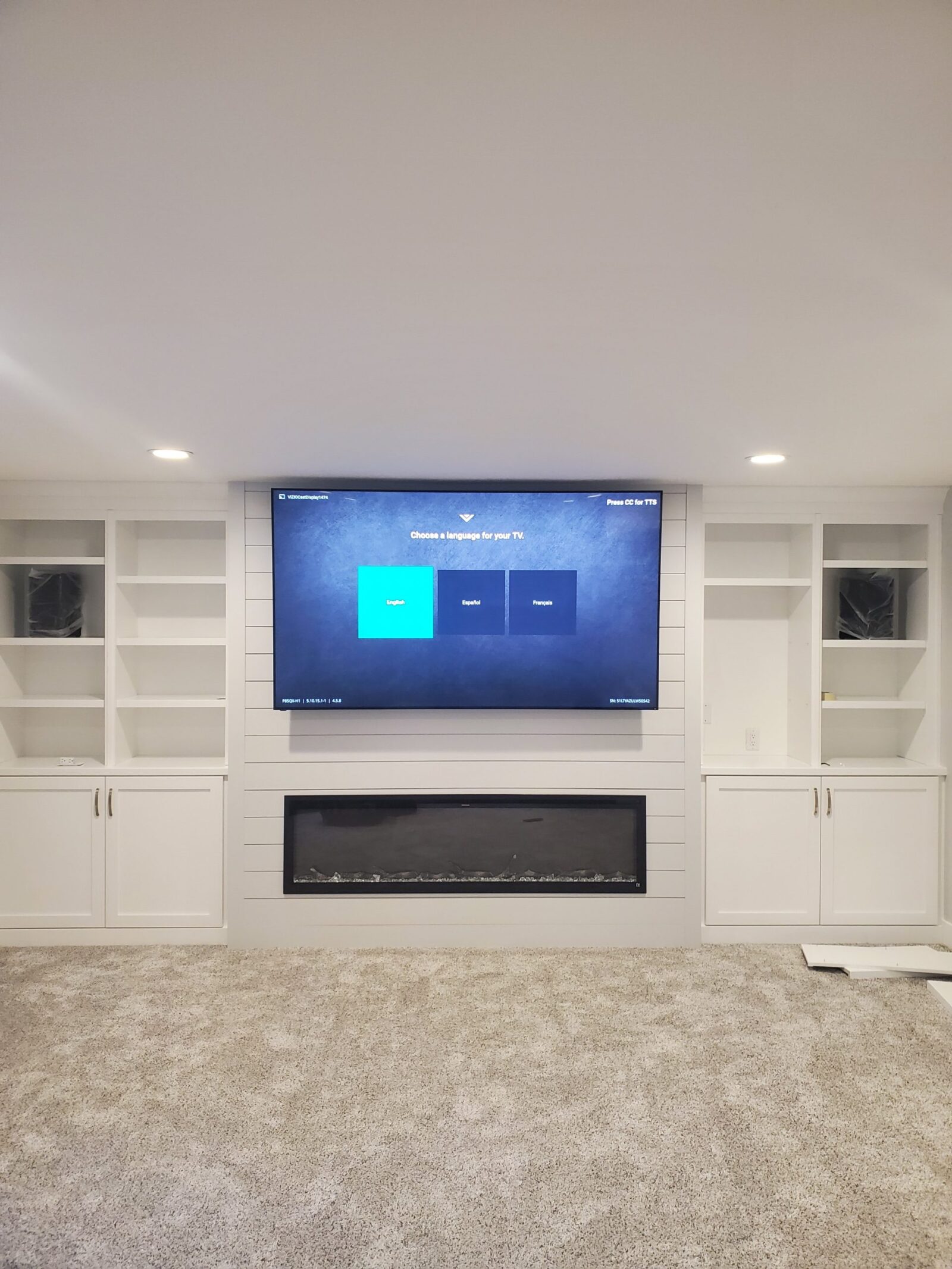 Mounted TV above a modern fireplace with built-in shelves